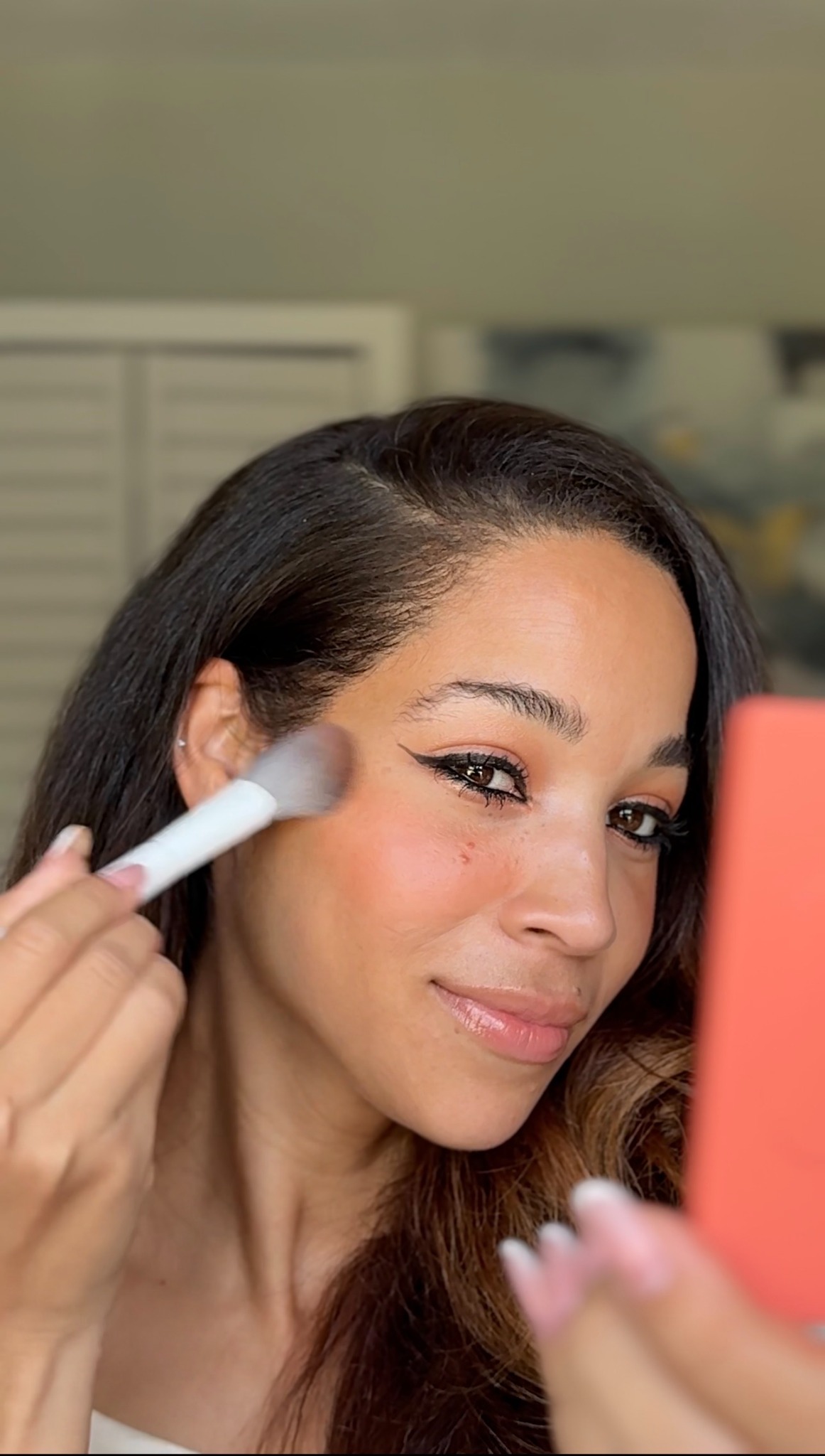 Arlety applying makeup with a brush