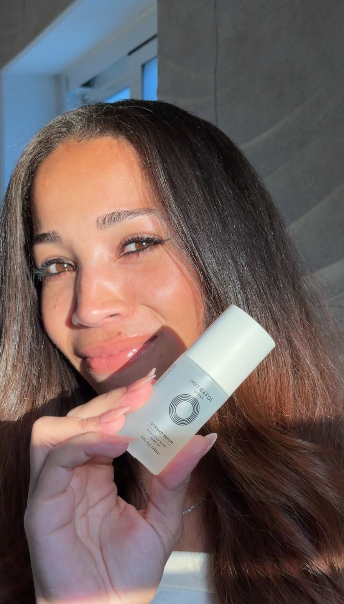 Arlety holding Nutrafol strand serum